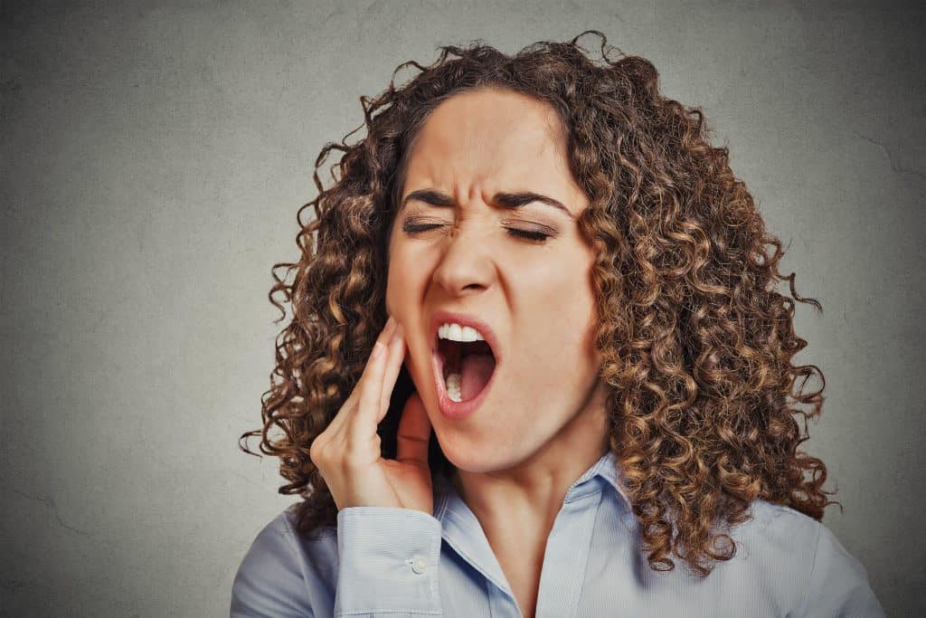 Lady experiencing sensitivity from gum disease
